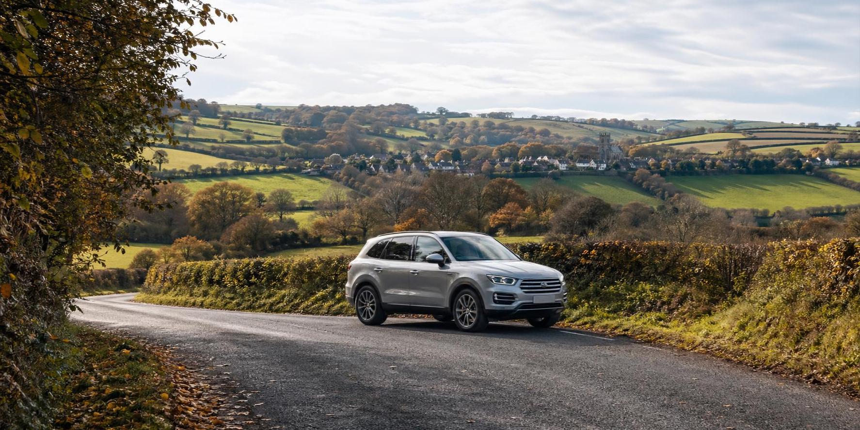 Silver SUV on a winding rural road with village views near Chulmleigh
